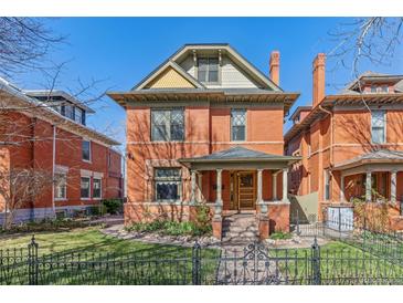 Charming two-story brick home featuring a quaint front porch and well-maintained landscaping at 1345 N Franklin St, Denver, CO 80218