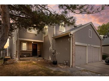 Charming two-story home featuring a two-car garage and a welcoming front porch at sunset at 14822 E Penwood Pl # D, Aurora, CO 80015