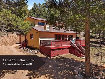 Charming two-story home with a spacious deck and a detached garage nestled among mature trees at 10852 Conifer Mountain Rd, Conifer, CO 80433