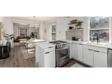 Modern kitchen featuring stainless steel appliances, white countertops and cabinetry, and seamless open layout at 2705 N Lafayette St, Denver, CO 80205