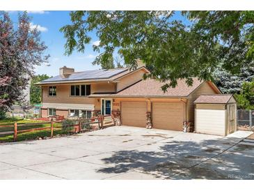 Inviting two-story home with a charming facade, large driveway, and solar panels on the roof at 8165 W Stene Dr, Littleton, CO 80128