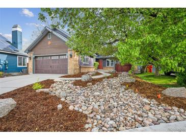 Charming home with a well-manicured front yard featuring rock landscaping and lush greenery at 10729 Kipling Way, Broomfield, CO 80021