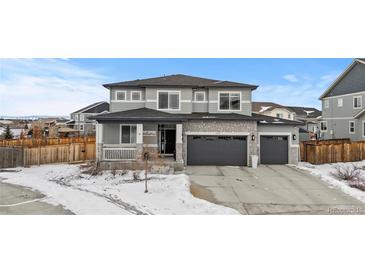 Two-story house with gray siding, three-car garage, and landscaping at 11633 Norfolk St, Commerce City, CO 80022