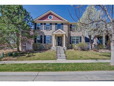 Charming two-story home with well-maintained lawn, brick facade, and black shutters for a classic curb appeal at 8641 Coors St, Arvada, CO 80005