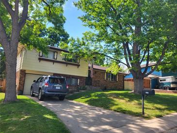 Charming two-story home with a well-manicured lawn and mature trees lining the property at 6649 Van Gordon Ct, Arvada, CO 80004