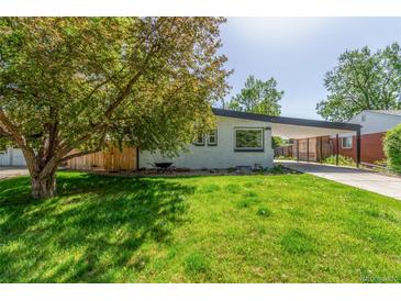 Charming home with lush front yard and covered parking offers great curb appeal at 1570 S Chase St, Lakewood, CO 80232