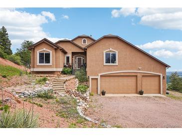 Stunning stucco home featuring a three-car garage and beautiful rock landscaping at 13084 Deer Ridge Way, Larkspur, CO 80118