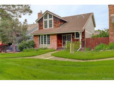 Charming brick and shingle home featuring mature landscaping and a tile roof at 7409 E Jamison Dr, Centennial, CO 80112