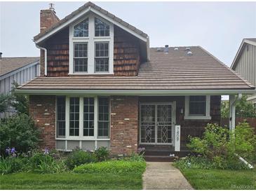 Charming two-story brick home with a well-manicured lawn and lush garden landscaping at 7409 E Jamison Dr, Centennial, CO 80112