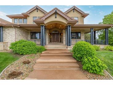 Inviting home entrance featuring a charming arched doorway and manicured landscaping at 14154 Lexington Cir, Westminster, CO 80023