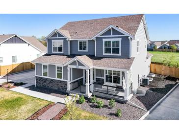 Charming two-story home featuring a cozy front porch and manicured landscaping at 437 Buckskin Rd, Berthoud, CO 80513