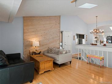 Bright living room features hardwood floors, skylight, vaulted ceilings and a rustic wood accent wall at 4009 Wonderland Hill Ave, Boulder, CO 80304