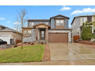Charming two-story home with a stone facade and a well-maintained lawn at 1820 Ghost Dance Cir, Castle Rock, CO 80108