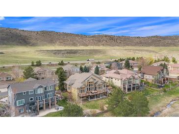Stunning aerial view showcasing a neighborhood with mountain views and lush greenery in a desirable location at 11065 W Rockland Dr, Littleton, CO 80127