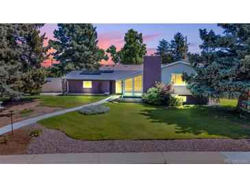 Charming single-Gathering home with a well-manicured lawn and beautiful landscaping at dusk at 1830 Zang St, Golden, CO 80401