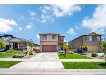 Charming two-story home with a well-manicured lawn and attached two-car garage at 502 Ledge St, Brighton, CO 80603