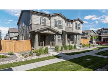 Charming townhome featuring a covered porch, low maintenance landscaping, and neutral exterior colors at 28330 E 6Th Pl, Watkins, CO 80137