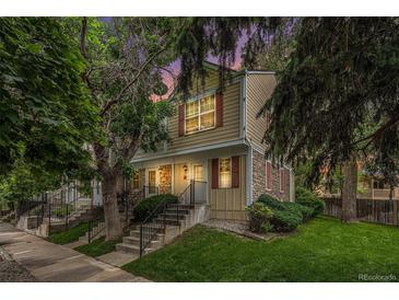 Charming townhome exterior with red shutters, stone accents, and a well-maintained lawn at 9519 W Coal Mine Ave # F, Littleton, CO 80123