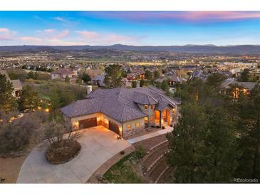 Stunning aerial view of a spacious home with a large driveway, surrounded by trees and overlooking a beautiful landscape at 4605 Tierra Alta Dr, Castle Rock, CO 80104