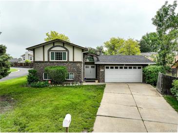 Charming brick and siding home with a well-maintained lawn and a two-car garage at 9642 Meade Ct, Westminster, CO 80031