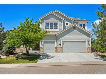 Beautiful two-story home with a three car garage, stone accents, and mature landscaping at 10441 Carriage Club Dr, Lone Tree, CO 80124