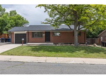 Charming brick home features a well-maintained front yard and attached garage at 6176 Ammons St, Arvada, CO 80004