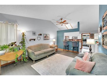Inviting living room featuring a vaulted ceiling, bar seating, and an open floor plan at 5323 E Sandpiper Ave, Castle Rock, CO 80104