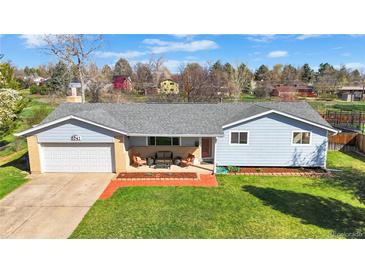 Charming single-story home with manicured lawn and welcoming front porch seating area at 5747 W Elmhurst Ave, Littleton, CO 80128