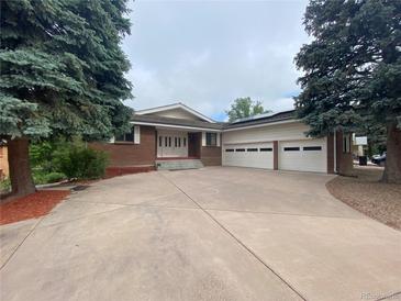 Charming brick home with large driveway and a three-car garage at 7079 Estes Dr, Arvada, CO 80004
