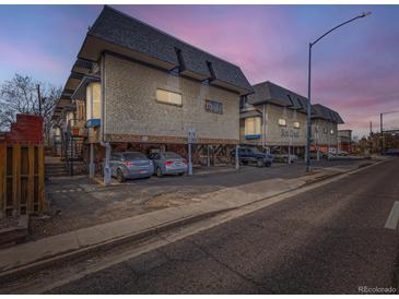 Apartment complex with ample parking and vintage architecture, featuring elevated units and brick facade at 1265 Colorado Blvd # 7, Denver, CO 80206