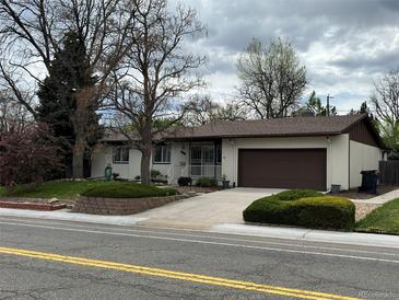 Charming single-story home features a well-maintained front yard and a two-car garage at 6085 Simms St, Arvada, CO 80004