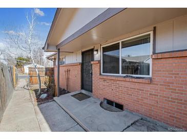 Cozy brick home featuring a secure front door and covered porch area at 4940 W 9Th Ave, Denver, CO 80204