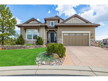 Charming home with a well-manicured lawn and stone accents, complemented by a two-car garage at 10698 Mountaingate Ct, Littleton, CO 80126