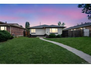 Charming single-story home with a well-manicured lawn and inviting walkway to the front door at 3640 Forest St, Denver, CO 80207