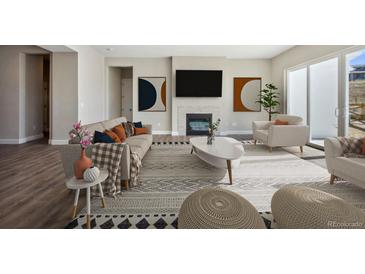 Modern living room with stylish furniture, a fireplace, large windows, and contemporary artwork creating an inviting space at 17054 Hop Clover Ave, Parker, CO 80134