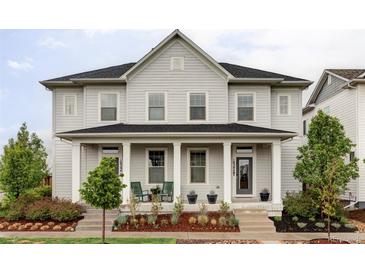 Charming two-story home with a well-maintained front yard and inviting front porch at 10384 E 60Th Pl, Denver, CO 80238