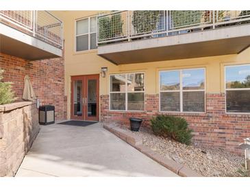 Exterior entrance to building shows a brick facade, walkway, and updated windows and balconies at 9079 E Panorama Cir # 520, Englewood, CO 80112