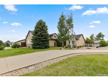 Inviting home featuring a well-manicured lawn, mature trees, and a spacious driveway leading to the attached garage at 8007 Sunrise Cir, Frederick, CO 80516