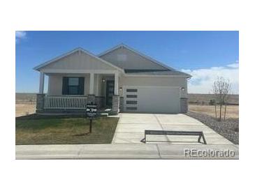 Charming single-Gathering home with a covered porch and a two-car garage, set against a clear blue sky at 42974 Colonial Trl, Elizabeth, CO 80107