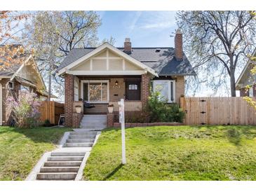 Charming brick bungalow with inviting front porch and well-manicured lawn at 4244 Grove St, Denver, CO 80211