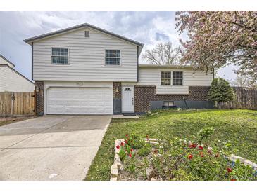 Charming two-story home with a brick-accented facade, well-manicured lawn, driveway, and garage at 9120 W Bellwood Pl, Littleton, CO 80123