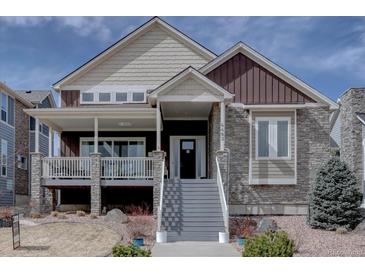 Charming two-story home with mixed stone and siding, covered porch, and well-maintained landscaping at 4483 Fell Mist Way, Castle Rock, CO 80109