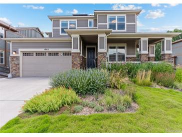 Charming two-story home with a well-manicured lawn, covered porch, stone accents, and a spacious two-car garage at 1902 Pioneer Cir, Lafayette, CO 80026
