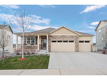 Charming ranch-style home with a covered porch, stone accents, and a three-car attached garage at 2080 Shadow Creek Dr, Castle Rock, CO 80104