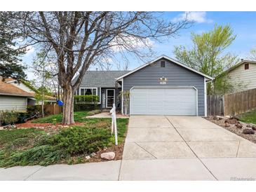 Charming gray home featuring mature landscaping, a two-car garage, and welcoming curb appeal at 8896 W Teton Cir, Littleton, CO 80128