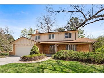 Charming two-story home with well-manicured lawn and mature landscaping adding to its curb appeal at 9004 E Floyd Ave, Denver, CO 80231