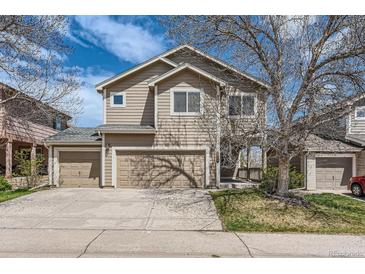 Two-story home featuring a two car garage and well-maintained lawn, with a blue sky at 2229 Hyacinth Rd, Highlands Ranch, CO 80129