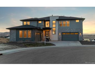 Stunning two-story home boasts a three-car garage, stone accents, and manicured landscaping for curb appeal at 730 Edenborn Pl, Castle Rock, CO 80104