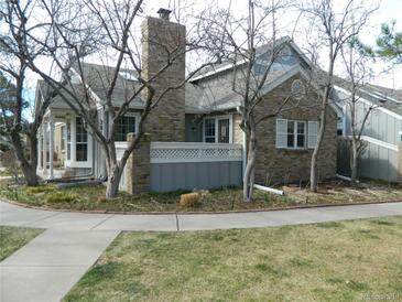 Charming brick-and-gray exterior with mature trees and well-maintained landscaping at 3011 W Long Ct # F, Littleton, CO 80120