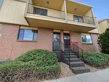 Brick townhouse exterior with balcony and steps leading to the entrance at 750 Tabor St # 18, Lakewood, CO 80401